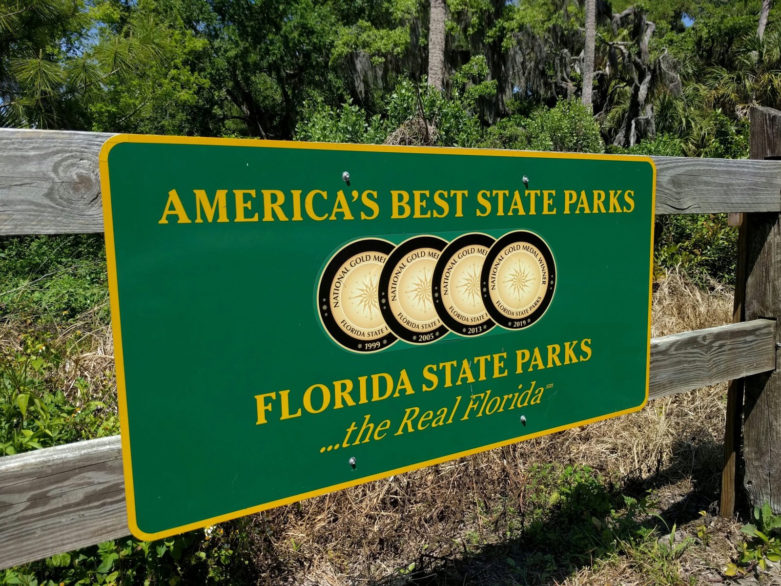 a sign for the florida state parks in front of a wooden fence